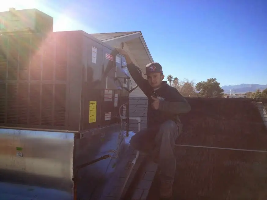HVAC technician performing Heat Pump Repair on a rooftop unit in North Oaks